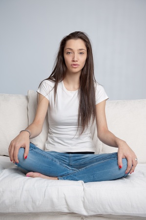 
Young woman sitting on a sofa cross-legged
の写真素材