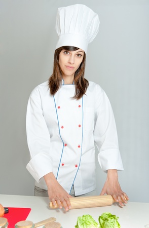 

Young woman in chefs attire using a rolling pin

の写真素材