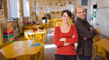 Young woman and man smiling on an elementary school classroomの写真素材