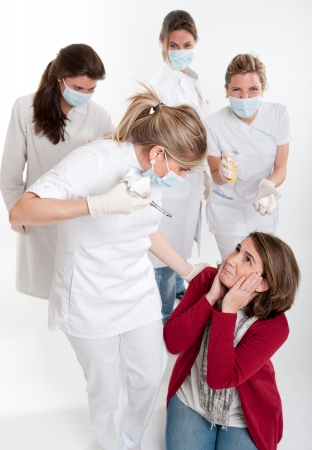 


A woman on her knees surrounded by an aggressive group of female dentists

の写真素材