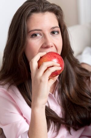 
Young brunette eating a red apple
の写真素材