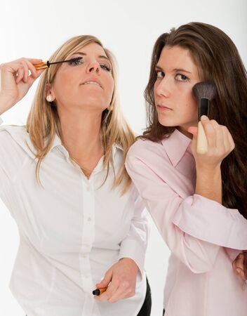 
A pair of young women applying make-up, getting ready to go out
の写真素材