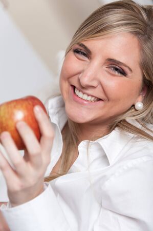 
Cheerful young blonde holding an apple
の写真素材