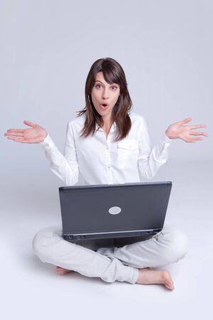 

Barefoot young woman using her computer cross-legged on the floor with her arms stretched out with a surprised expression


の写真素材