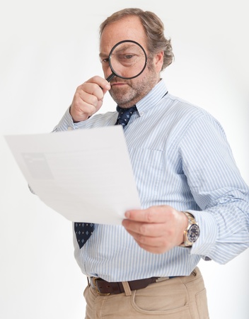 
Man inspecting a document through a magnifying glass 
の写真素材