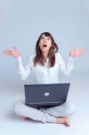 

Barefoot young woman using her computer cross-legged on the floor with her arms stretched out with a surprised expression


の写真素材