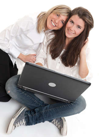 A pair of young laughing female friends using a laptopの写真素材