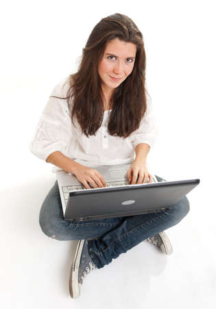 Attractive young brunette using a laptop on the floorの写真素材