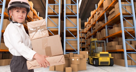 Child wearing a motorbike helmet carrying parcels in a transportation warehouseの写真素材