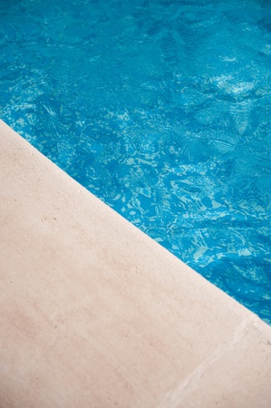 Enticing image of blue water and stone swimming pool edgeの写真素材