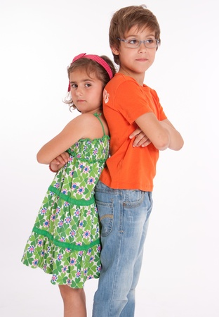 A boy  and little girl back to back with annoyed expressionsの写真素材