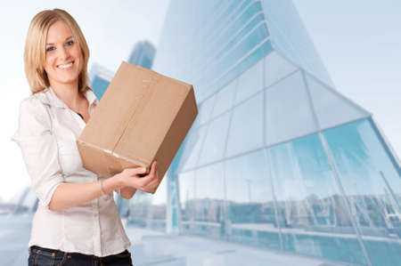 Smiling woman holding a parcel in the financial districtの写真素材