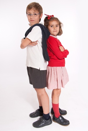 A boy  and little girl back to back with annoyed expressionsの写真素材