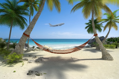 Exotic travel composition with a flying plane, a tropical beach with a hammock hanging from palm treesの写真素材