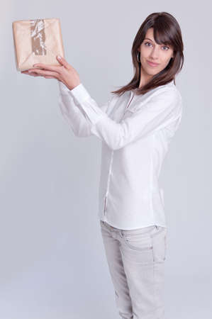 Young woman holding high a cardboard box with a happy expression の写真素材