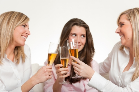 Three young female friends toasting with flutesの写真素材