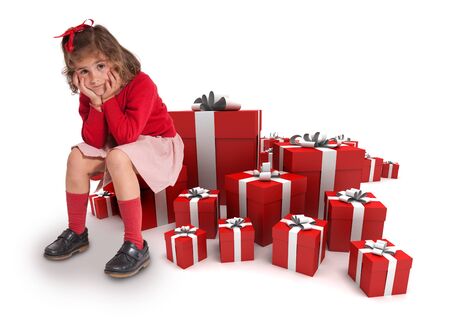 Sad little girl sitting surrounded by gift boxes の写真素材