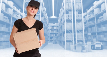 Female courier carrying a parcel in a distribution warehouseの写真素材