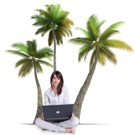 A girl sitting cross-legged on the floor with a laptop with palm trees in the backgroundの写真素材