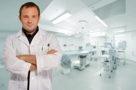 Reassuring male doctor with an operating room at the backgroundの写真素材