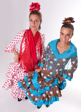 A pair of woman dress in the typical Sevillian folkloric costume in a dance poseの写真素材