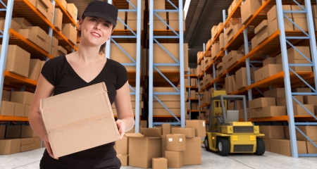 Female courier carrying a parcel in a distribution warehouseの写真素材