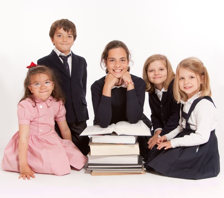 A group of school kids of different ages and a pile of booksの写真素材