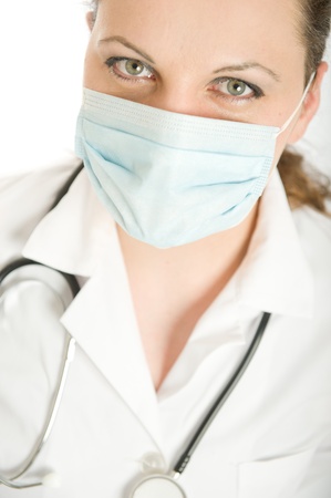 Female doctor with lab coat and stethoscope wearing a maskの写真素材