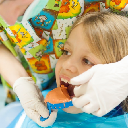 Orthtodontis preparing teeth mold for little girlの写真素材