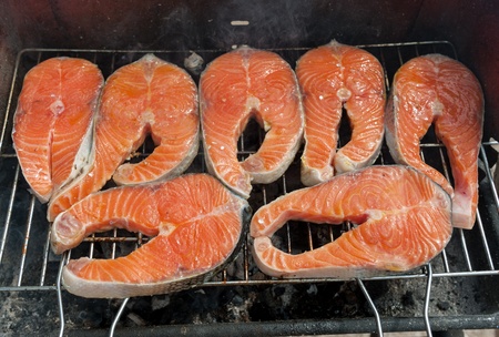 Salmon steaks grilling on the barbecueの写真素材