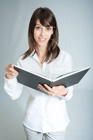 

Young brunette wearing a white shirt holding a book

の写真素材