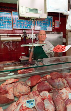 Butcher presenting a wrapping paper with ground beefの写真素材