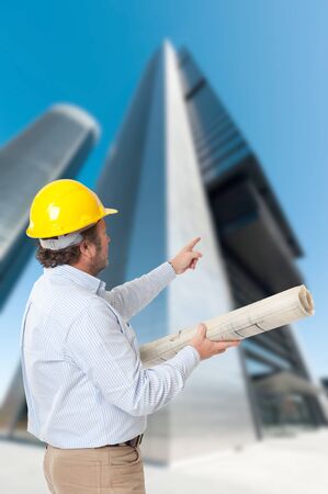 Man with helmet and blueprint and an old Parisian buildingの写真素材