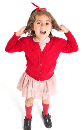 Little schoolgirl with a red uniform pulling her hairの写真素材