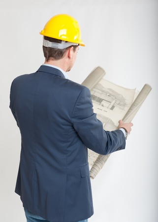 
Rear view of a man with a safety helmet consulting blueprints
の写真素材