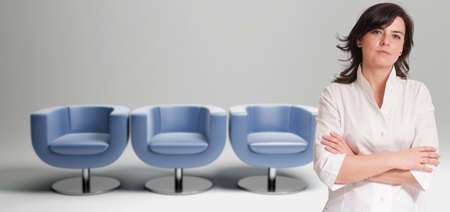 Attractive business woman with three empty seats on the backgroundの写真素材