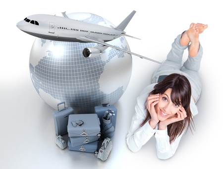Young woman lying on the floor by a pile of luggage the Earth and a flying plane の写真素材