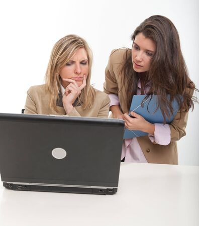 2 young women at work around a computerの写真素材