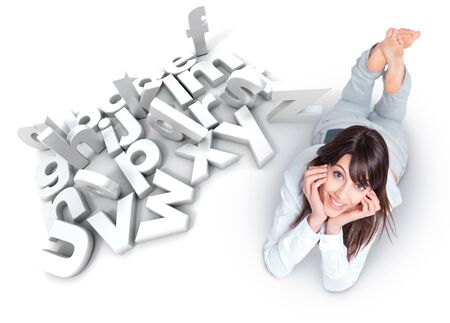 Young woman lying by a white alphabet with scattered lettersの写真素材
