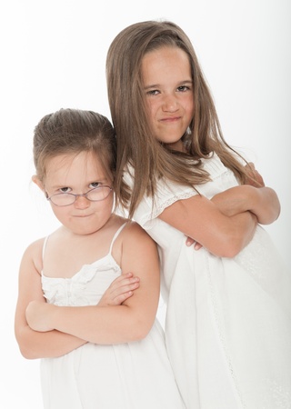 Two little sisters with angry expressionsの写真素材