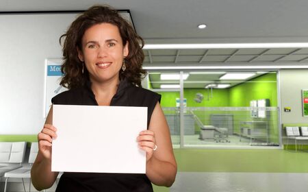 
Woman holding a blank board in a hospital interior
の写真素材