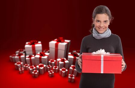 
Young girl holding a present against a background with gift boxes
の写真素材