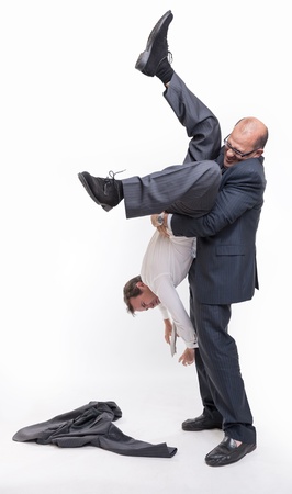 Big man holding another upside down by the anklesの写真素材