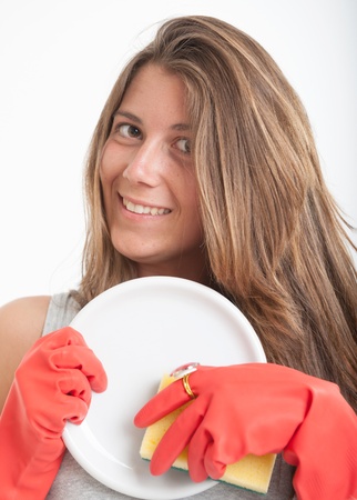 Young woman washing the dishes with glamorous glovesの写真素材
