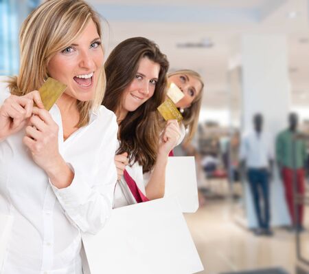 Three young women in a happy shopping expedition with credit cardsの写真素材