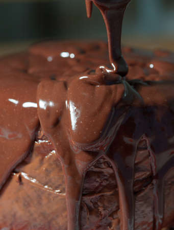 Melted chocolate falling on a cakeの写真素材