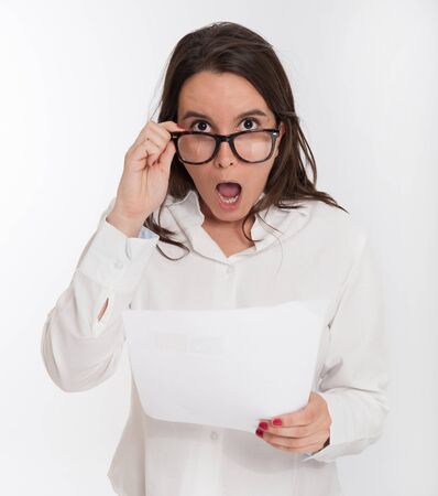 Young brunette looking shocked to a documentの写真素材