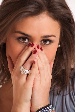 young brunette covering her face with her hands