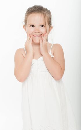 Cute little girl with a funny forced smileの写真素材