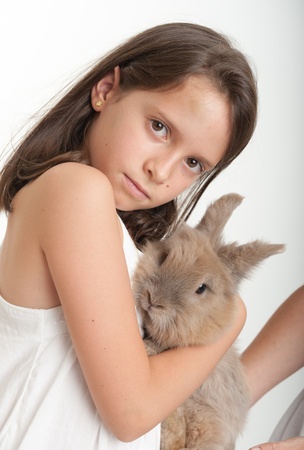 Young girl lovingly hugging her bunnyの写真素材